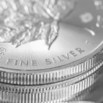 Up close image of silver Canadian coins sitting on a reflective surface