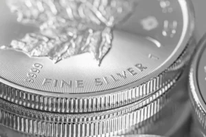 Up close image of silver Canadian coins sitting on a reflective surface